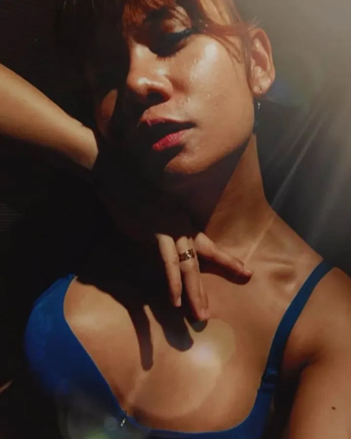 Femme arabe aux cheveux bruns, en soutien-gorge bleu, posant dans une lumière dramatique