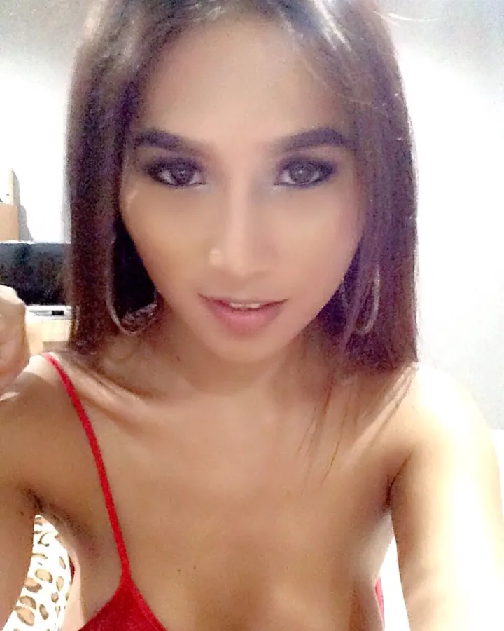 Jeune femme aux cheveux châtains en t-shirt noir, prenant un selfie
