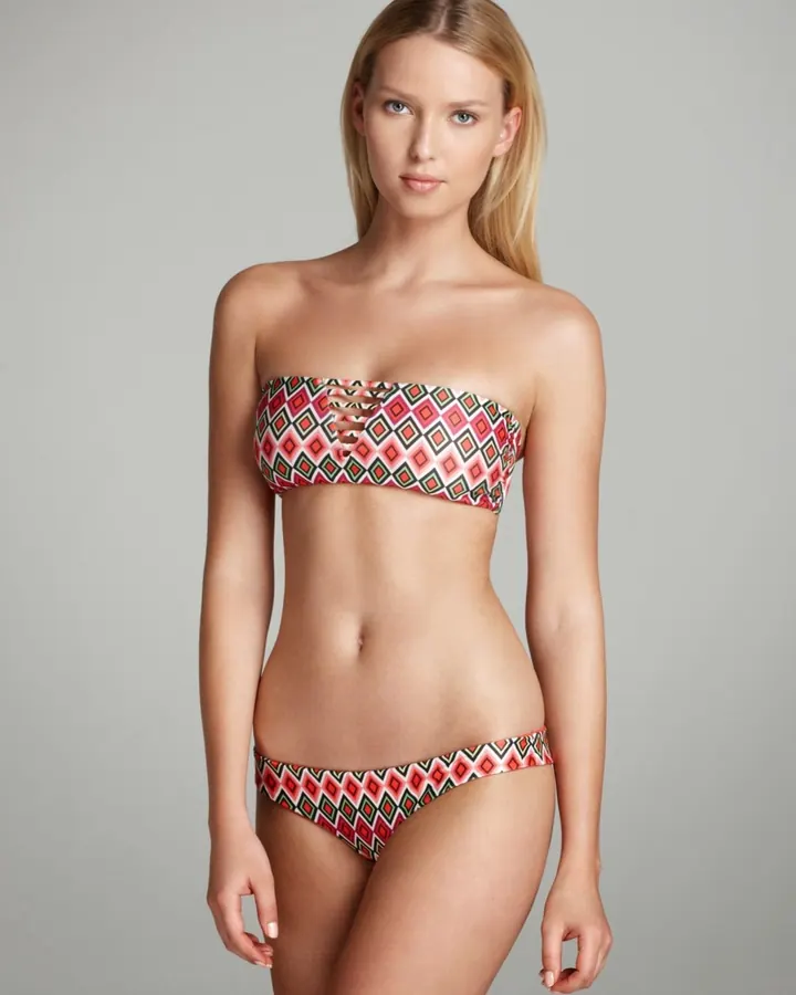 Femme blonde en lingerie multicolore géométrique, posant en studio.
